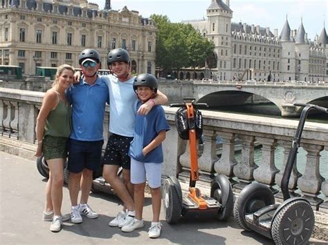 Groupe de touristes souriants participant à une visite en Segway devant un monument parisien