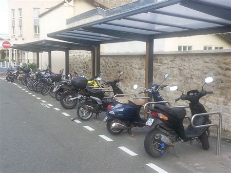 Exemple d'une aire de stationnement moto bien aménagée avec arceaux antivol et signalétique claire.