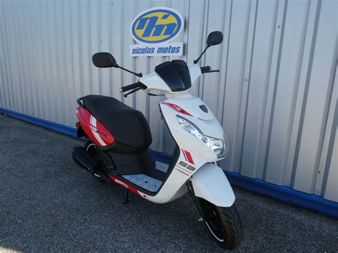 Vue latérale du Peugeot Kisbee TCR avec ses autocollants distinctifs et ses accents rouges.